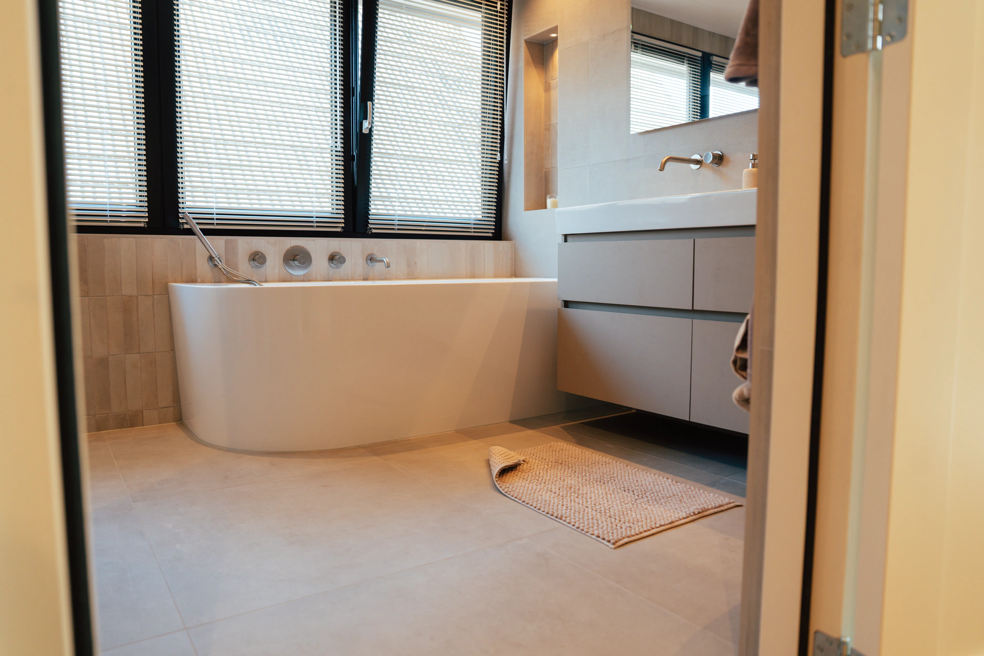 Gerenoveerde badkamer met vrijstaand bad en dubbele wastafel