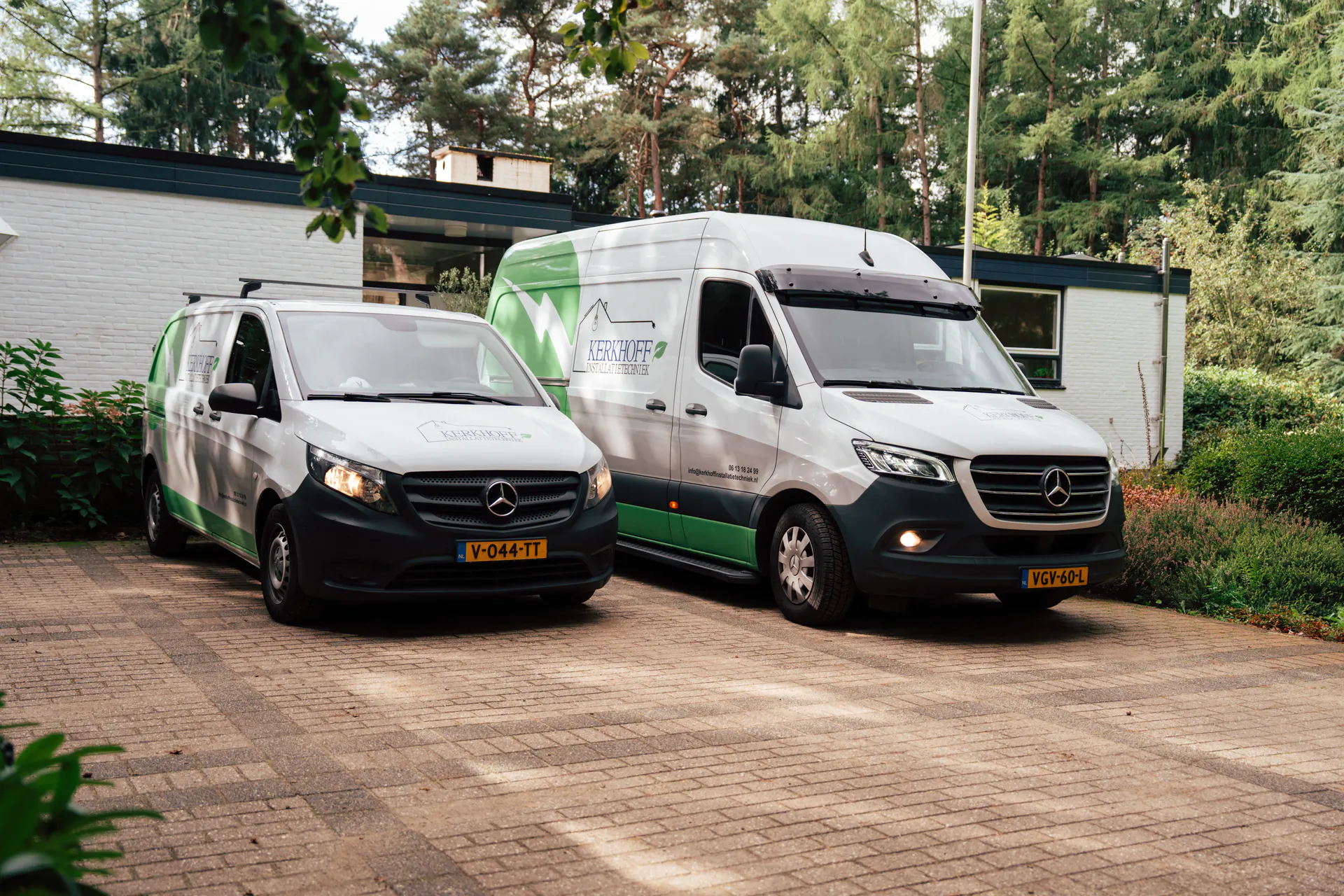 De bedrijfsbussen van Kerkhoff Installatietechniek op de oprit van een woning